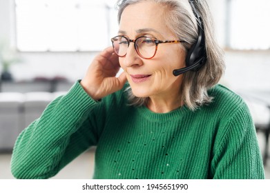 Portrait Of A Charming Elegant Senior Lady Wearing Headset And Glasses, A Mature Customer Service Representative Takes A Call, Close-up Portrait