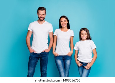 Portrait of charming family wearing white denim jeans looking with toothy smile isolated over blue background