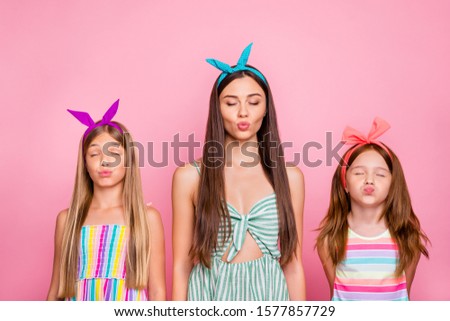 Portrait of charming ladies  sending air kisses having date wearing bright headband skirt dresses isolated over pink  background