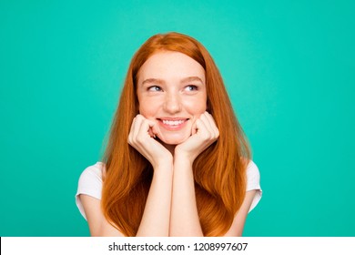 Portrait of charming, lovely, cute, beautiful, sweet lady look aside touch cheeks by hands fists and smile isolated on pastel turquoise background