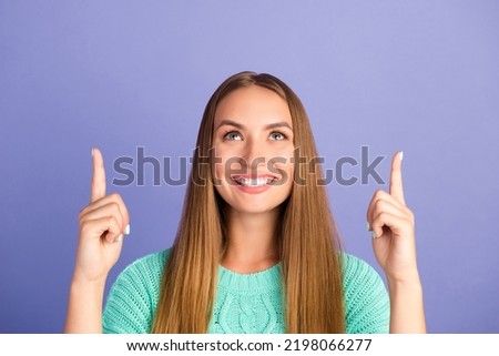 Portrait of charming positive person toothy smile look direct fingers up empty space isolated on purple color background