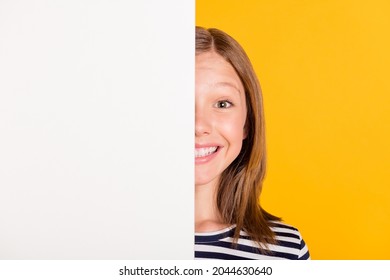 Portrait of charming positive young lady covering half face empty space wall isolated on yellow color background
