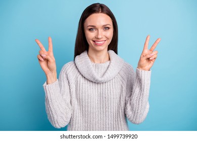 Portrait of charming sweet lady have free time make v-signs wear white knitted jumper isolated over blue color background - Shutterstock ID 1499739920