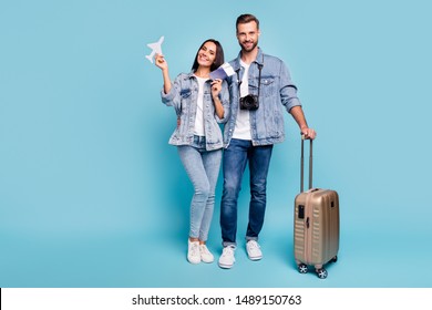 Portrait of charming sweethearts holding pack paper card plane hugging embracing wearing denim jeans jackets isolated over blue background - Powered by Shutterstock