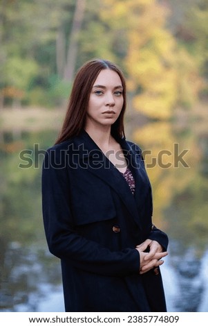 Portrait of a charming woman posing near a lake