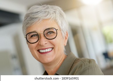 Portrait of a cheerful 55-year-old woman with white hair