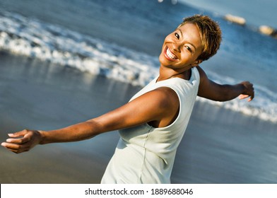 Portrait Of Cheerful African American Woman Enjoying Vacation On Beach