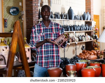 Portrait Of Cheerful Afro Male Shop Assistant In Pottery Shop