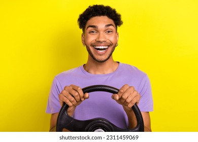Portrait of cheerful astonished young person beaming smile arms hold wheel isolated on yellow color background - Shutterstock ID 2311459069