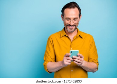 Portrait Of Cheerful Attractive Mature Man Modern Device User Use His Smart Phone Type Social Network Message Wear Good Looking Clothes Isolated Over Blue Color Background