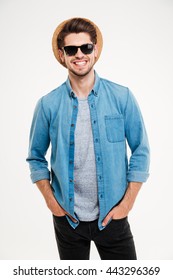 Portrait of cheerful attractive young man in hat and sunglasses over white background