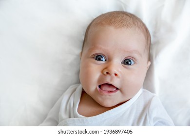 Portrait of a cheerful baby with big eyes. Light background