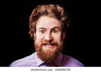 Portrait Of A Cheerful Bearded Man With Hair Standing Up On End Against A Black Background. Joyful View