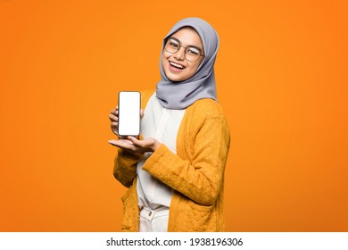Portrait of cheerful beautiful Asian woman showing blank screen on smartphone