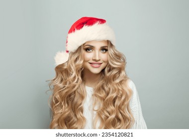 Portrait of cheerful blonde woman in Santa hat smiling on white banner background, Christmas model - Powered by Shutterstock