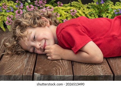 Portrait of cheerful boy lying on wood deck smiling