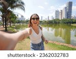 Portrait of cheerful Brazilian girl takes selfie in Vaca Brava Park in Goiania, Goias, Brazil