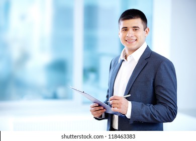 Portrait of cheerful businessman making notes and looking at camera - Powered by Shutterstock