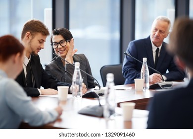 Portrait of cheerful businesswoman whispering to colleague during business meeting in conference room, copy space - Powered by Shutterstock