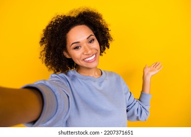 Portrait of cheerful charming girl make selfie record video arm palm demonstrate empty space isolated on yellow color background - Shutterstock ID 2207371651