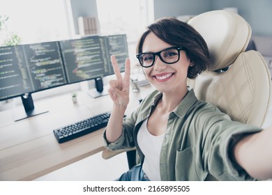 Portrait of cheerful charming hardware expert make selfie fingers show v-sign sitting chair office indoors