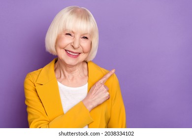 Portrait of cheerful charming person indicate finger empty space toothy smile isolated on purple color background - Powered by Shutterstock