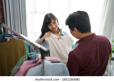 A portrait of a cheerful couple choosing and buying clothes. At the clothes shop