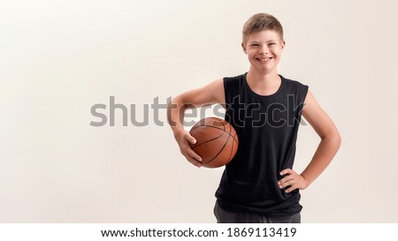 Similar – Teenage boy holding a basketball on a court