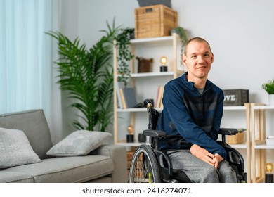 Portrait of a cheerful disabled man in wheelchair smiling at camera chilling at home - Powered by Shutterstock