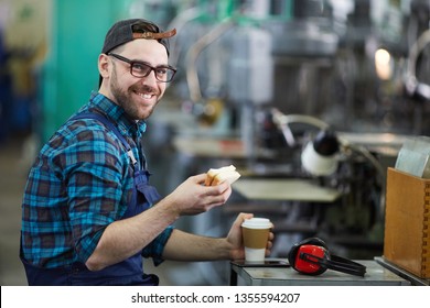 Portrait of cheerful factory worker eating sandwich during lunch break, copy space - Powered by Shutterstock