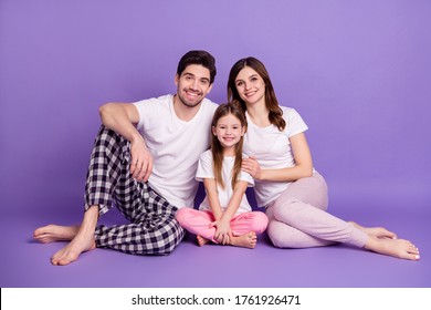 Portrait Of Cheerful Family Dad Mom Offspring Daughter Wearing Cozy Comfort Pajama Sitting On Floor Embracing Stay Home Quarantine Isolated On Bright Vivid Shine Vibrant Violet Color Background