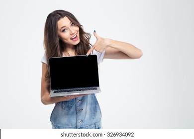 Portrait of a cheerful girl showing blank laptop computer screen isolated on a white background - Powered by Shutterstock