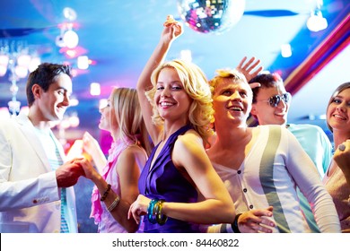 Portrait Of Cheerful Girls And Guys Dancing At Party