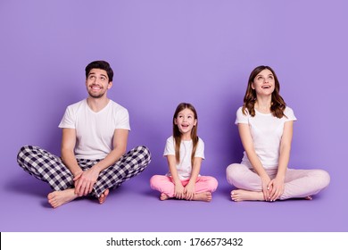 Portrait Of Cheerful Glad Family Dad Mom Offspring Daughter Wearing Cozy Cotton Pajama Sitting On Floor Looking Up Idea Copy Space Isolated On Bright Vivid Shine Vibrant Violet Color Background