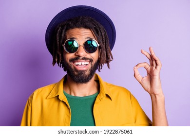 Portrait of cheerful guy front teeth gap smile fingers show okey symbol isolated on purple color background