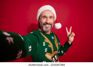 Portrait of cheerful handsome man make selfie hand fingers demonstrate v-sign isolated on red color background