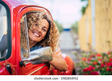 Portrait of cheerful happy adult pretty woman smile and enjoy driving car - caucasian female have fun outside the window of her vehicle - garden and road in background - people driving