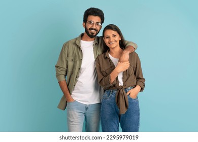 Portrait of cheerful happy stylish beautiful young indian couple hipsters posing together on colorful studio background, embracing and smiling at camera. Love, relationships, affection - Powered by Shutterstock