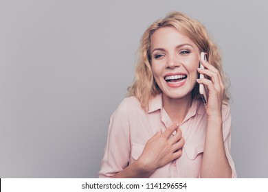 Portrait of cheerful and happy young woman speaking on smart phone isolated on gray background - Shutterstock ID 1141296554