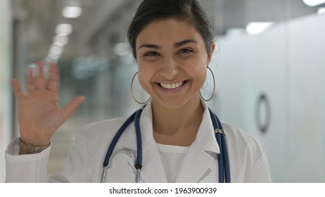 Portrait Of Cheerful Indian Female Doctor Waving At The Camera 