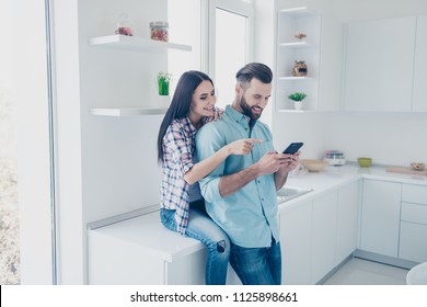 Portrait of cheerful joyful couple surfing internet enjoying online shopping using smart phone. Apps electronic wireless device technology social networks connection communication concept