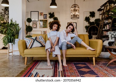 Portrait Of A Cheerful Lesbian Couple At A Yellow Couch