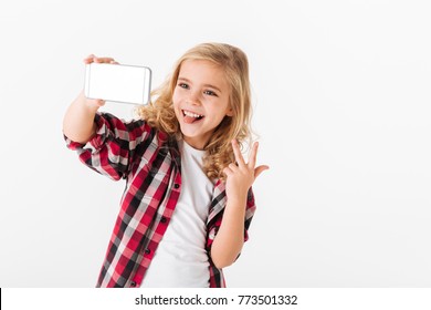 Portrait Of A Cheerful Little Girl Taking A Selfie Isolated Over White Background