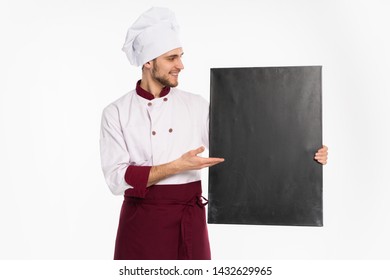 Portrait of a cheerful male chef cook in uniform holding blank board isolated on a white background