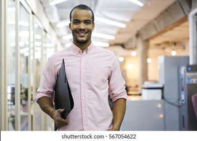 Portrait of cheerful male employee of media marketing company ready for hard working day in coworking office preparing documents and financial reports for showing executive on morning meeting 