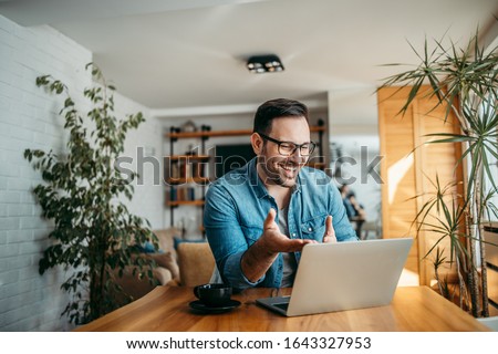 Portrait of a cheerful man having video call on laptop computer.