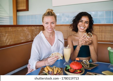 Portrait Of Cheerful Multiracial Best Friends Smiling At Camera During Positive Meeting Split Mexican Lunch, Happy Female Customers Enjoying Tex Mex Food During Pastime For Taste Latin Cuisine