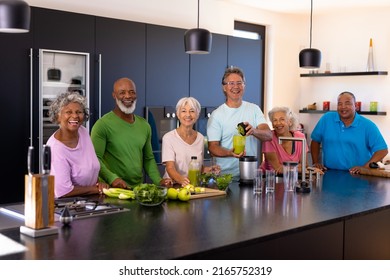 Portrait of cheerful multiracial senior friends preparing smoothie in kitchen at retirement home. Unaltered, togetherness, support, assisted living, enjoyment, retirement and healthy food concept. - Powered by Shutterstock