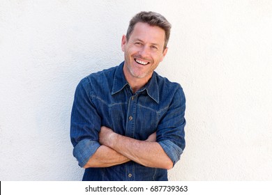 Portrait Of Cheerful Older Man Standing With Arms Crossed