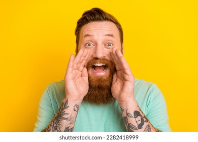 Portrait of cheerful overjoyed positive man wear stylish green clothes share interesting news isolated on yellow color background
